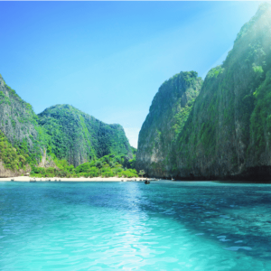 Maya Bay tropical bay with towering limestone cliffs covered in lush green vegetation.