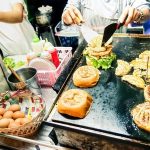 Busy food stall with people cooking and serving food
