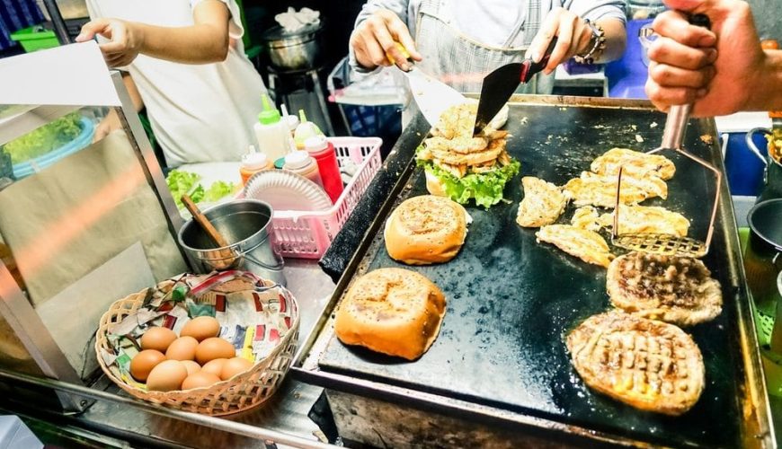 Busy food stall with people cooking and serving food