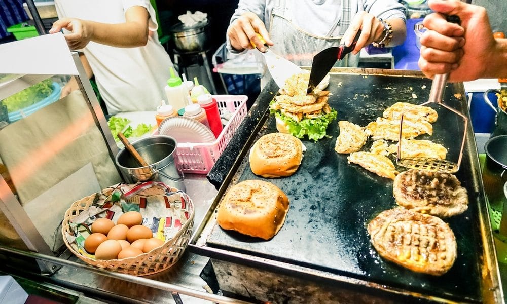 Busy food stall with people cooking and serving food