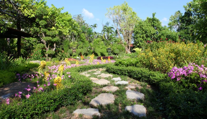 A garden with colorful flowers and a stone path.