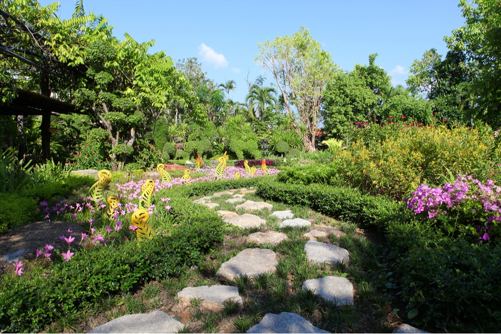 A garden with colorful flowers and a stone path.