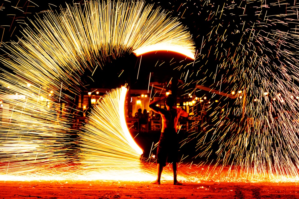 Fire show performance on a beach at night