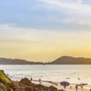 Sunset over beach with people walking